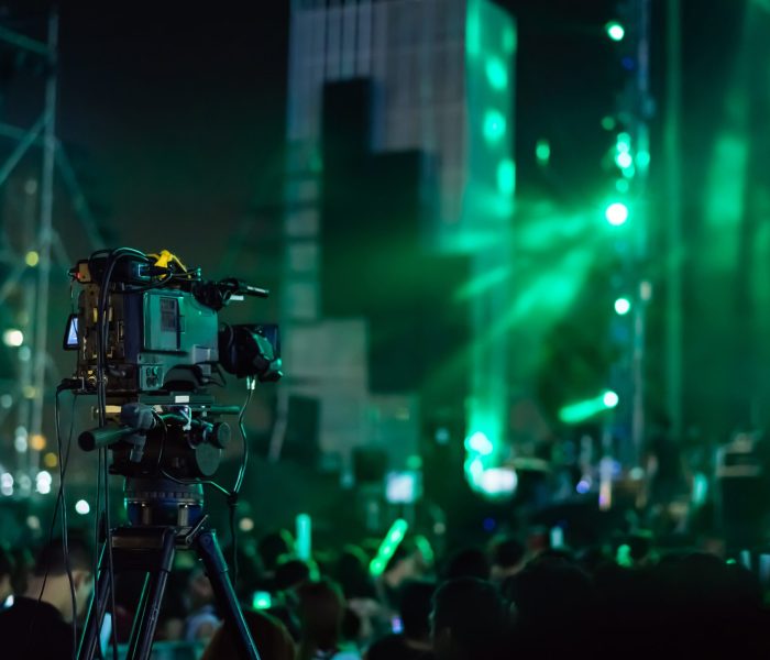 Video camera starting record concert live streaming show in the tv on the front stage lights with crowd fan in music festival